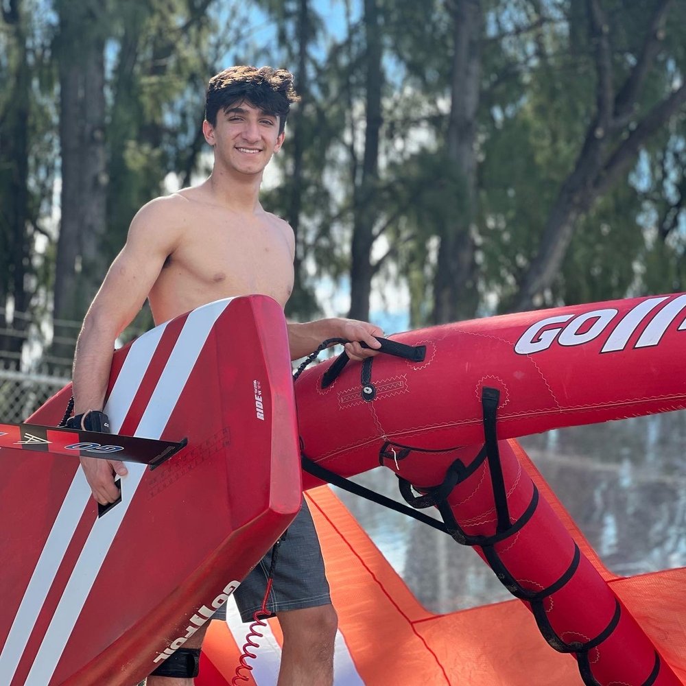 Rider with wing foiling equipment at a Maui beach